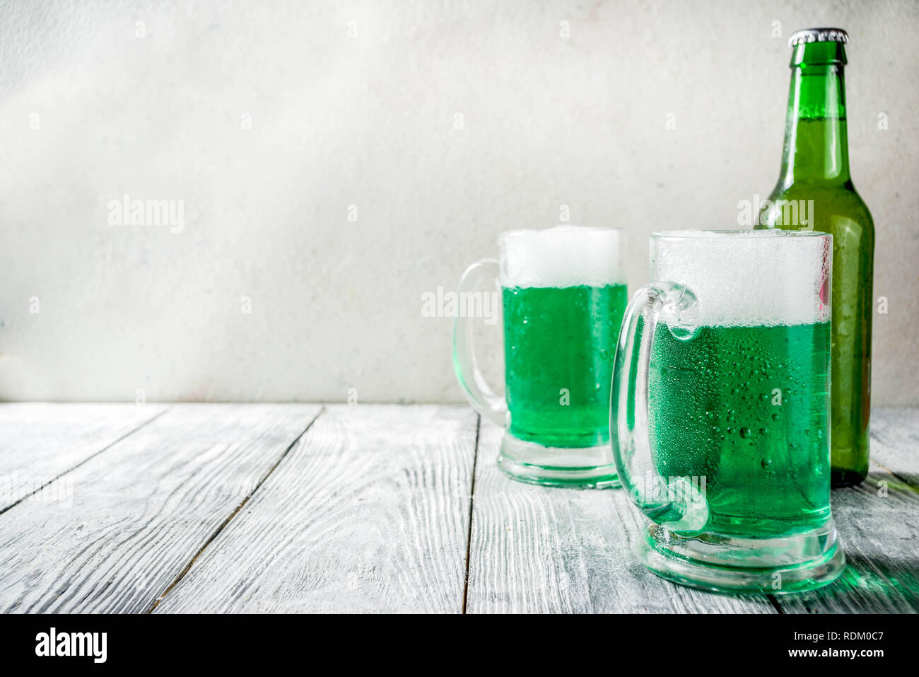 https://c8.alamy.com/comp/RDM0C7/st-patricks-day-concept-two-glasses-and-bottle-with-cold-fresh-cold-green-beer-on-wooden-table-bar-counter-background-for-st-patricks-day-and-ok-RDM0C7.jpg