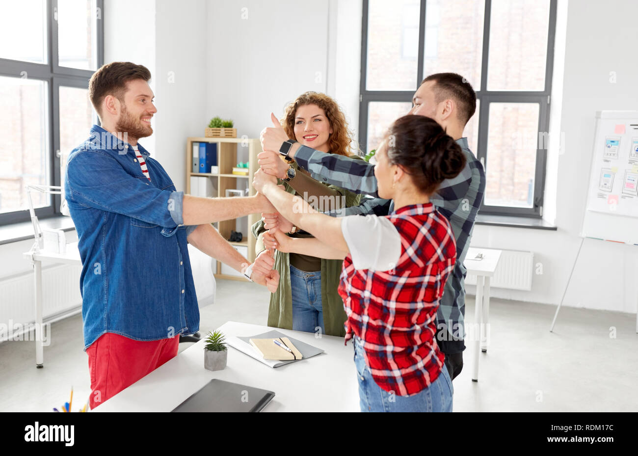 happy creative team showing thumbs up at office Stock Photo - Alamy