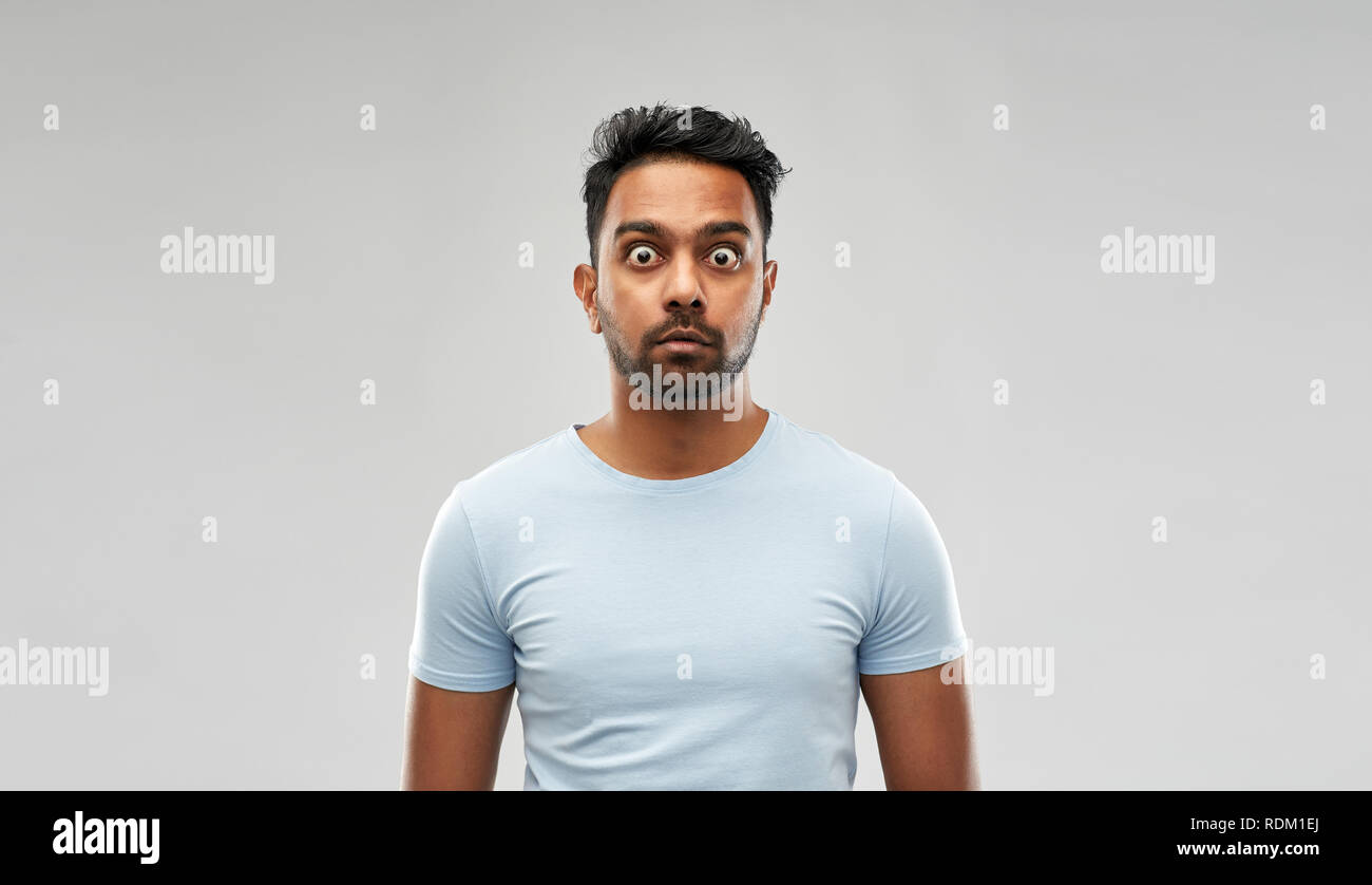 shocked or scared man over grey background Stock Photo