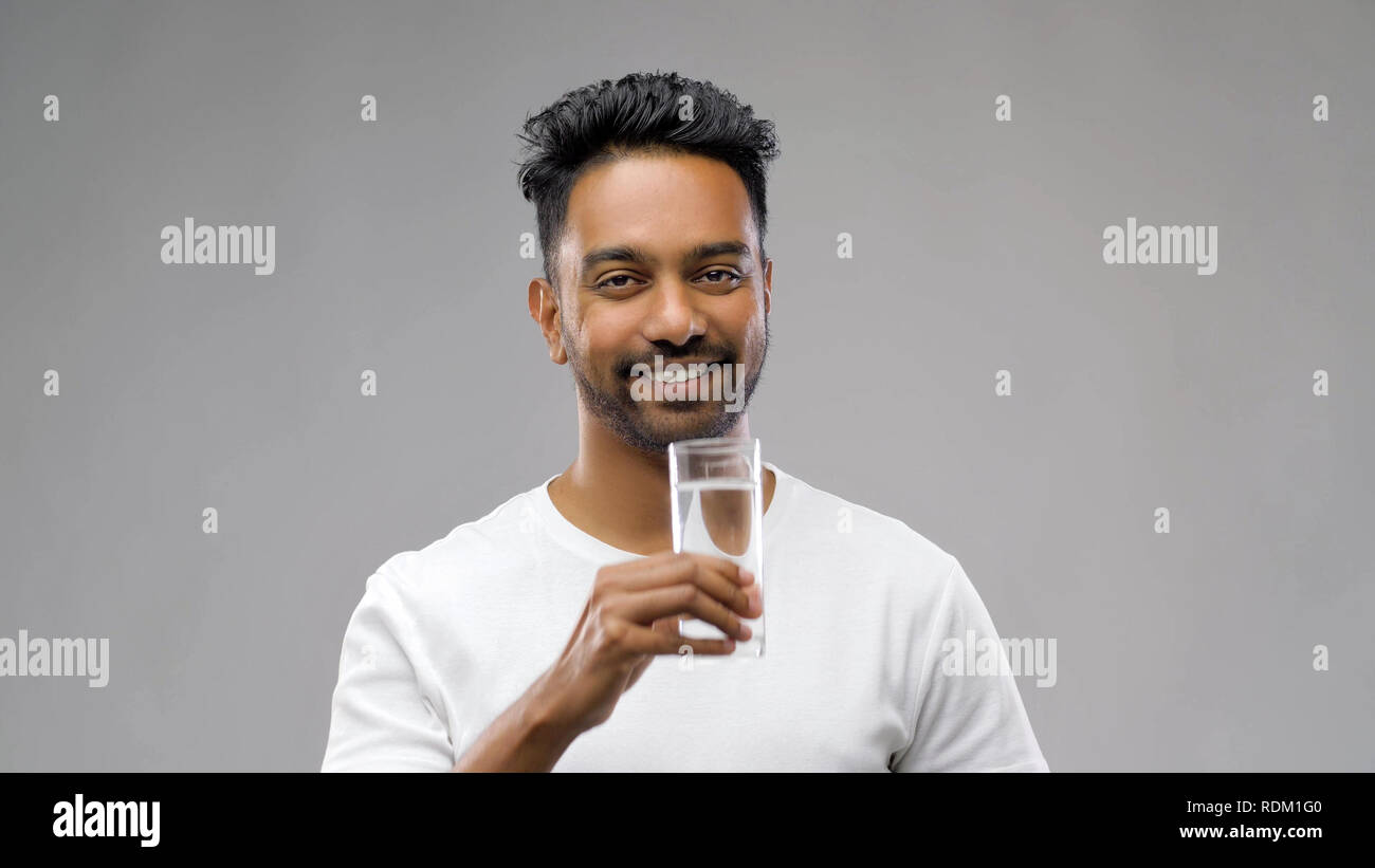 happy young indian man drinking water from glass Stock Photo - Alamy
