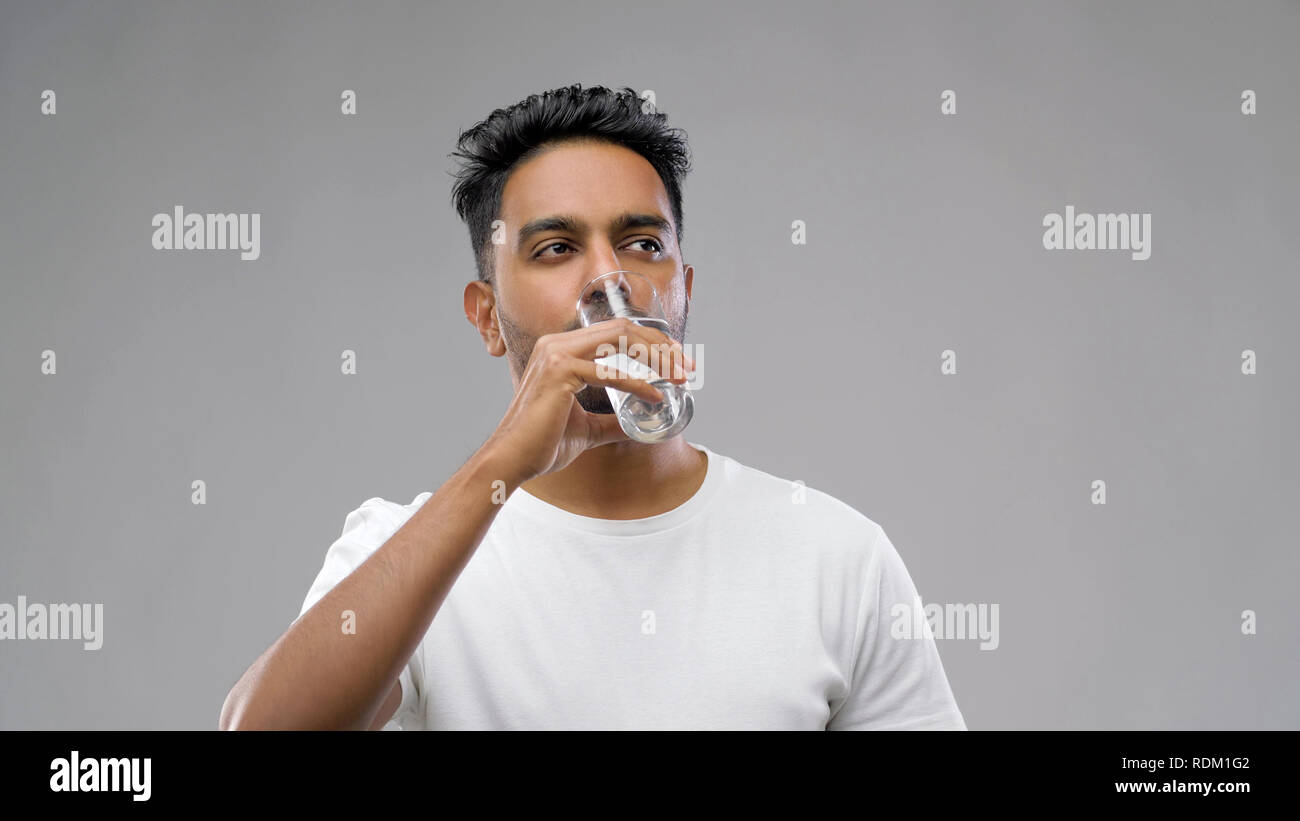 happy young indian man drinking water from glass Stock Photo - Alamy