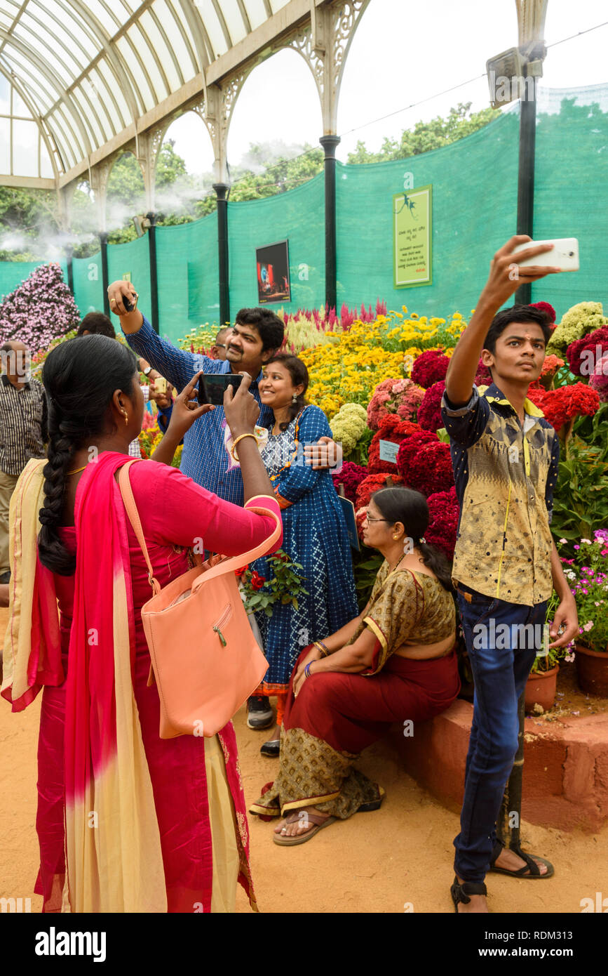 Indian visitors taking selfis at the flower show, Lalbagh Botanical Gardens, Banaglore, Bengaluru, Karnataka, India Stock Photo