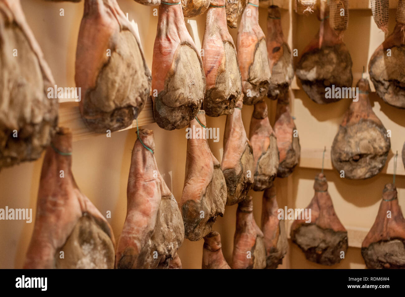 Raw hanging prosciutto Stock Photo