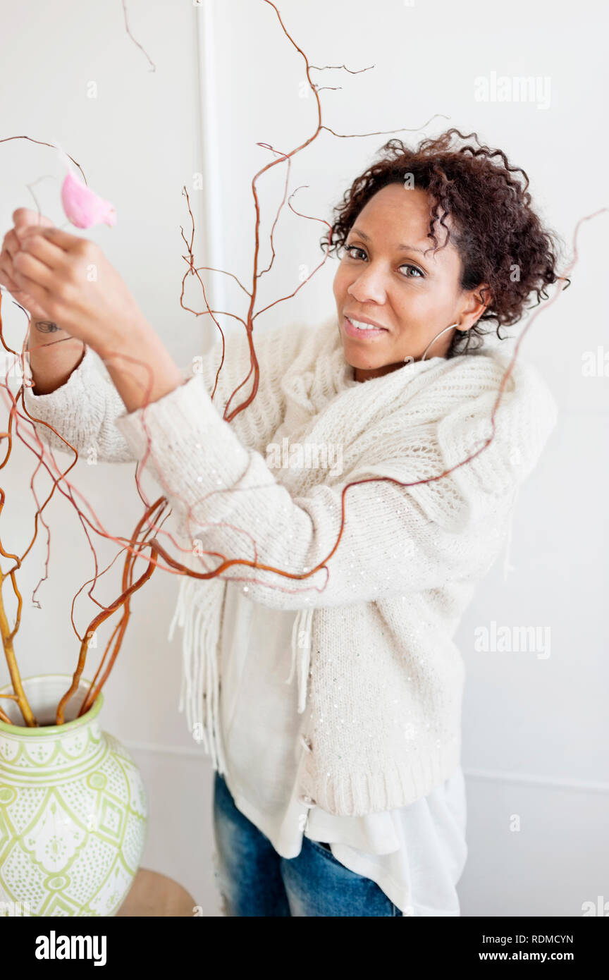 Mature woman decorating twigs Stock Photo