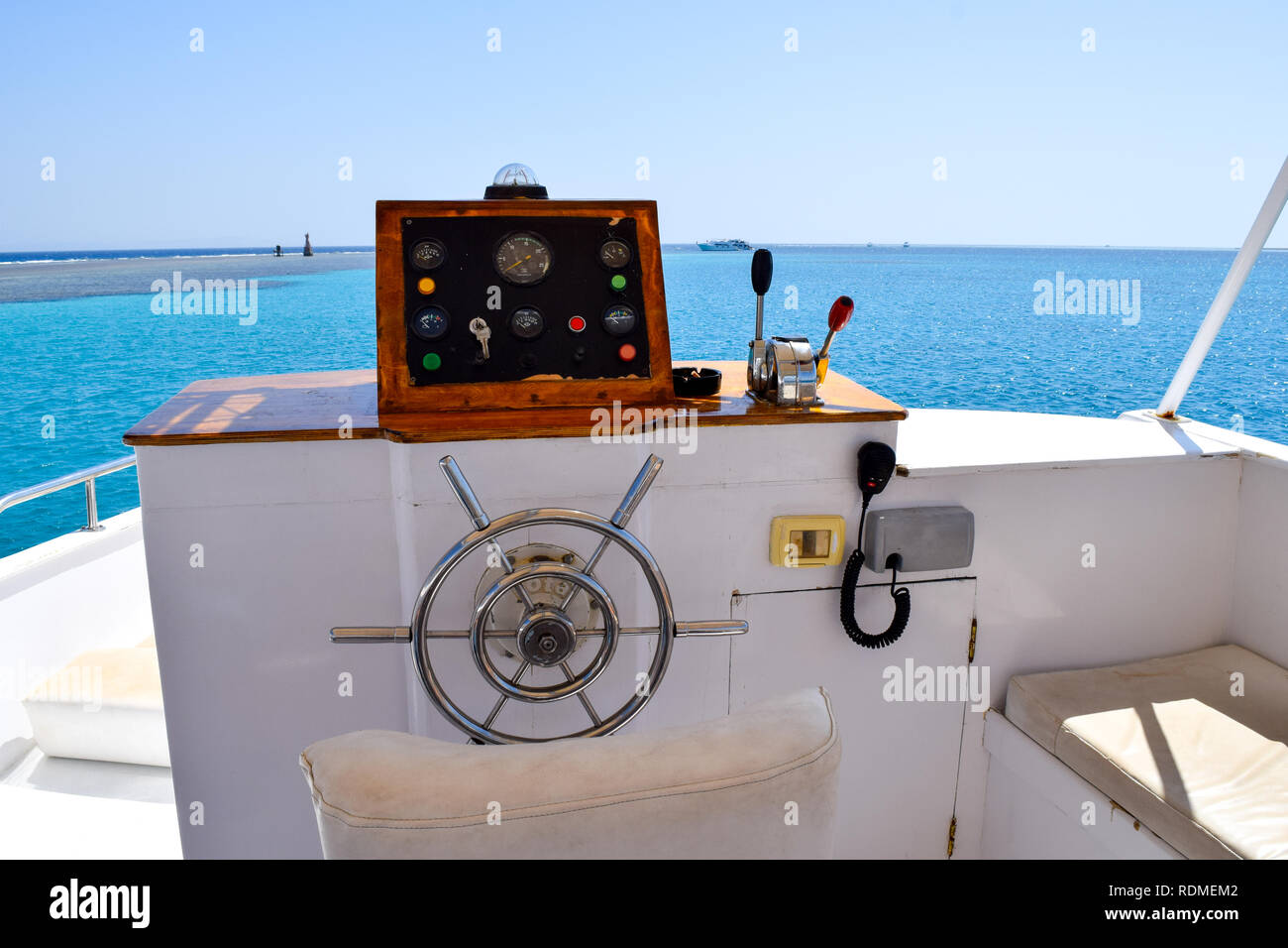 View over old boat steering wheel into the turquoise ocean Stock Photo