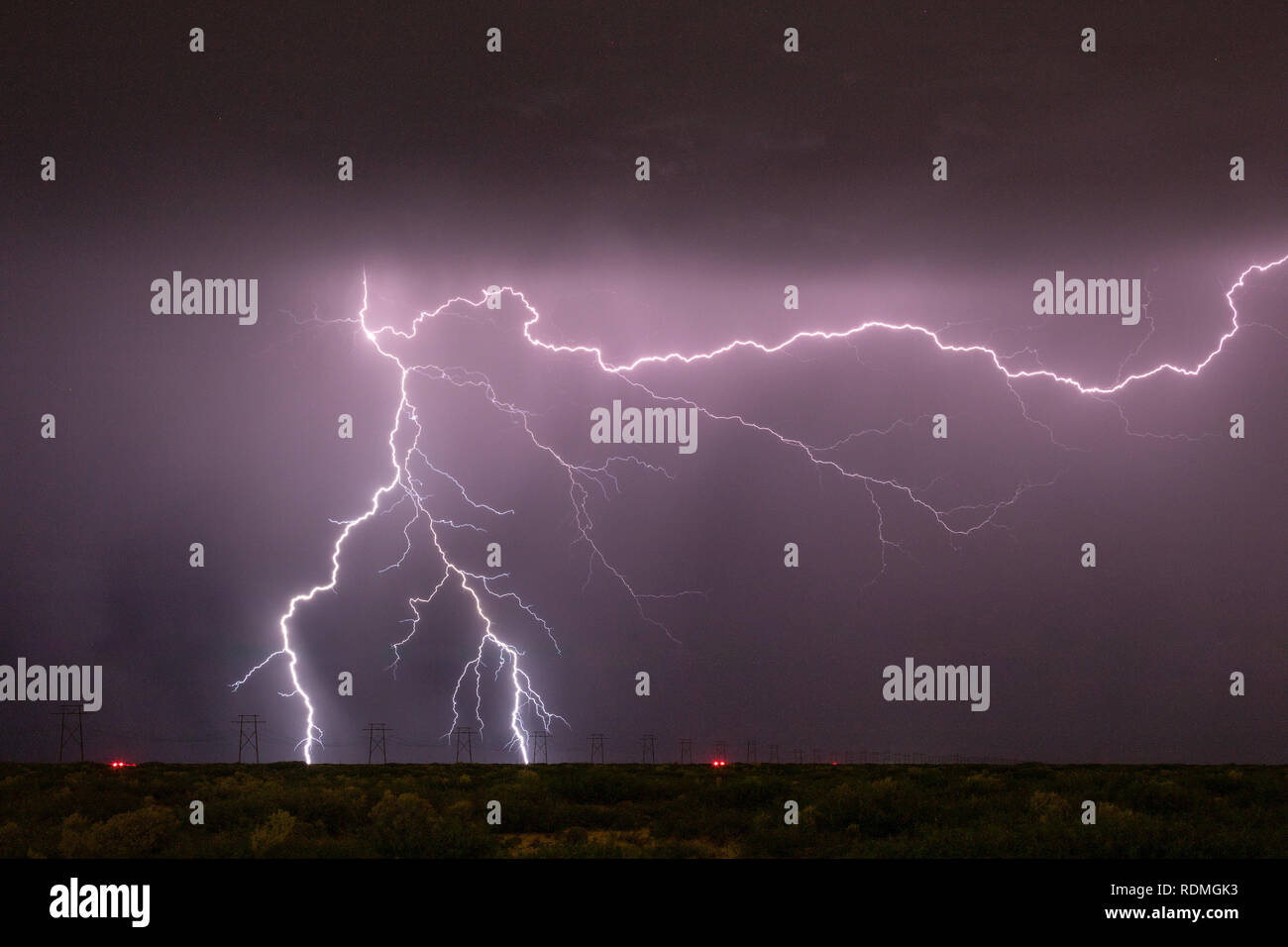Cloud to ground lightning strikes near high tension power lines Stock