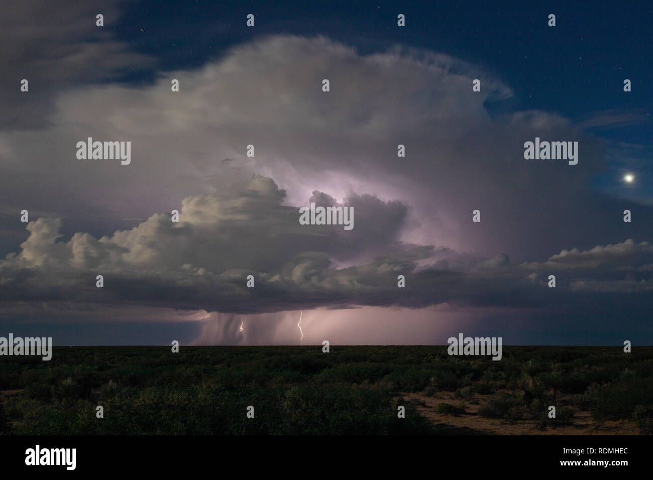 A lone thunderstorm dwarfs the moon near the USMexico Border in New