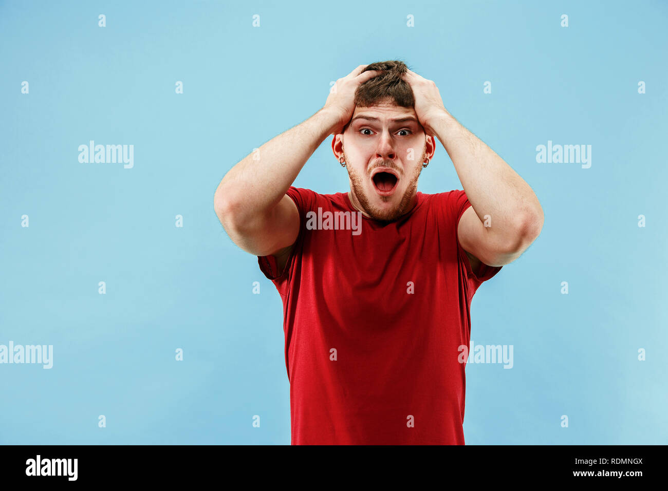 Young boy with a surprised unhappy failure expression bet slip on blue ...
