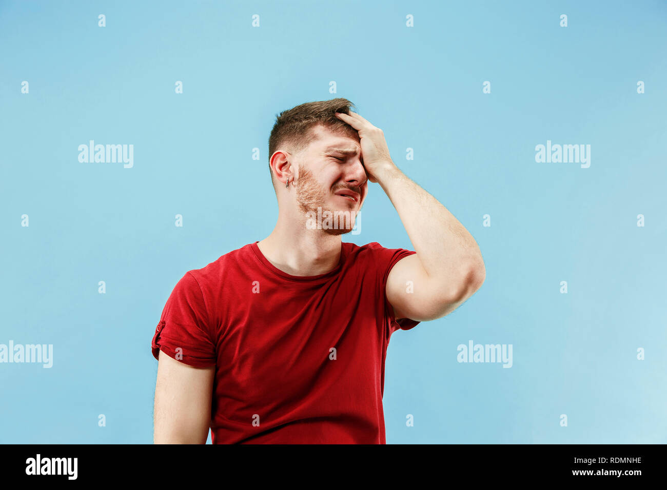 Young boy with a surprised unhappy failure expression bet slip on blue ...