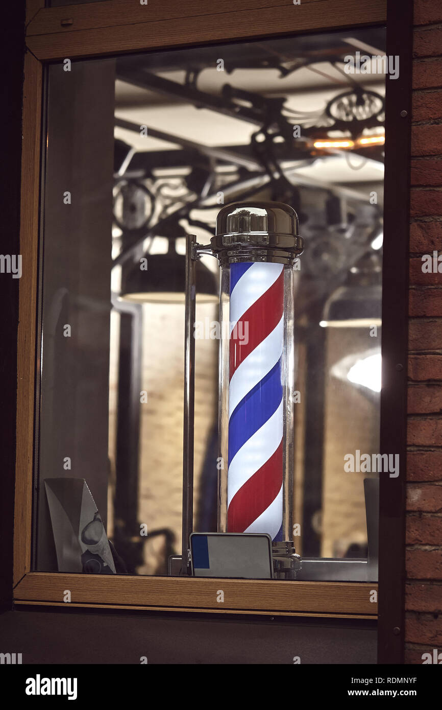 The Barber Shop. The famous symbol of a barber shop with it swirling red, blue and white stripes. Stock Photo