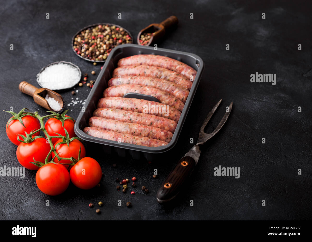 Raw beef and pork sausage in plastic tray with vintage knife and fork