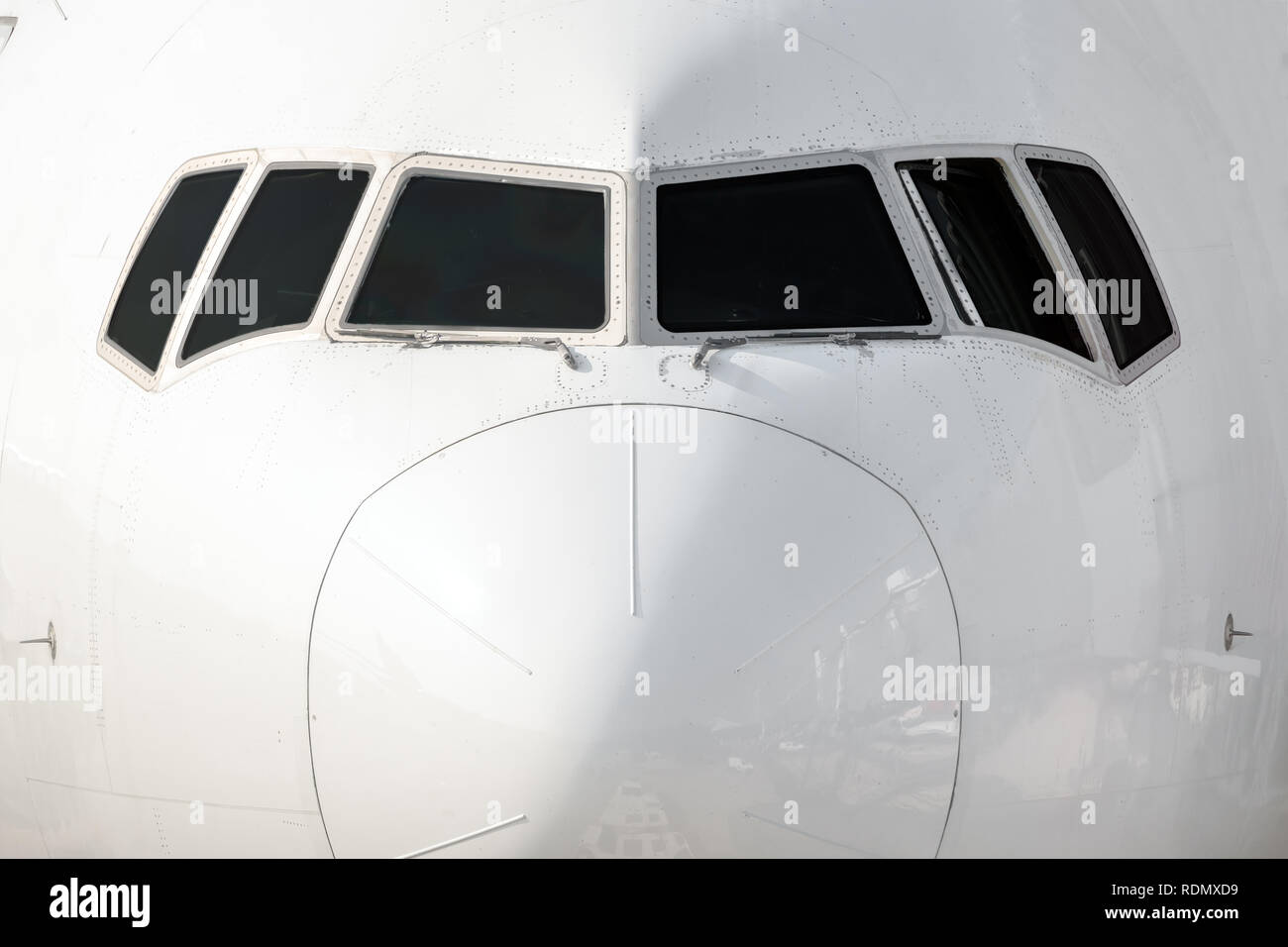 Close front outside view of a white big jet plane cockpit. Stock Photo
