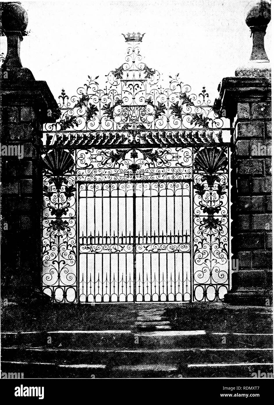 . Gardens for small country houses. Gardens. Gates and Gateways. 199 not fallen under the spell of Tijou or at least of his book of designs. The horizontal lines are heavily emphasised and the embossed shells at the top of the side panels are unusually prominent. The &quot;overthrow&quot; of the gate is very marked by the range of embossed acanthus leaves (derived apparentl}' from Tijou's gadroon and acanthus border) which connect the two stout horizontals supporting the pyramid of scrollwork, etc. A rather unusual feature is the trio of oval rings at the base of each side panel. The embossed  Stock Photo