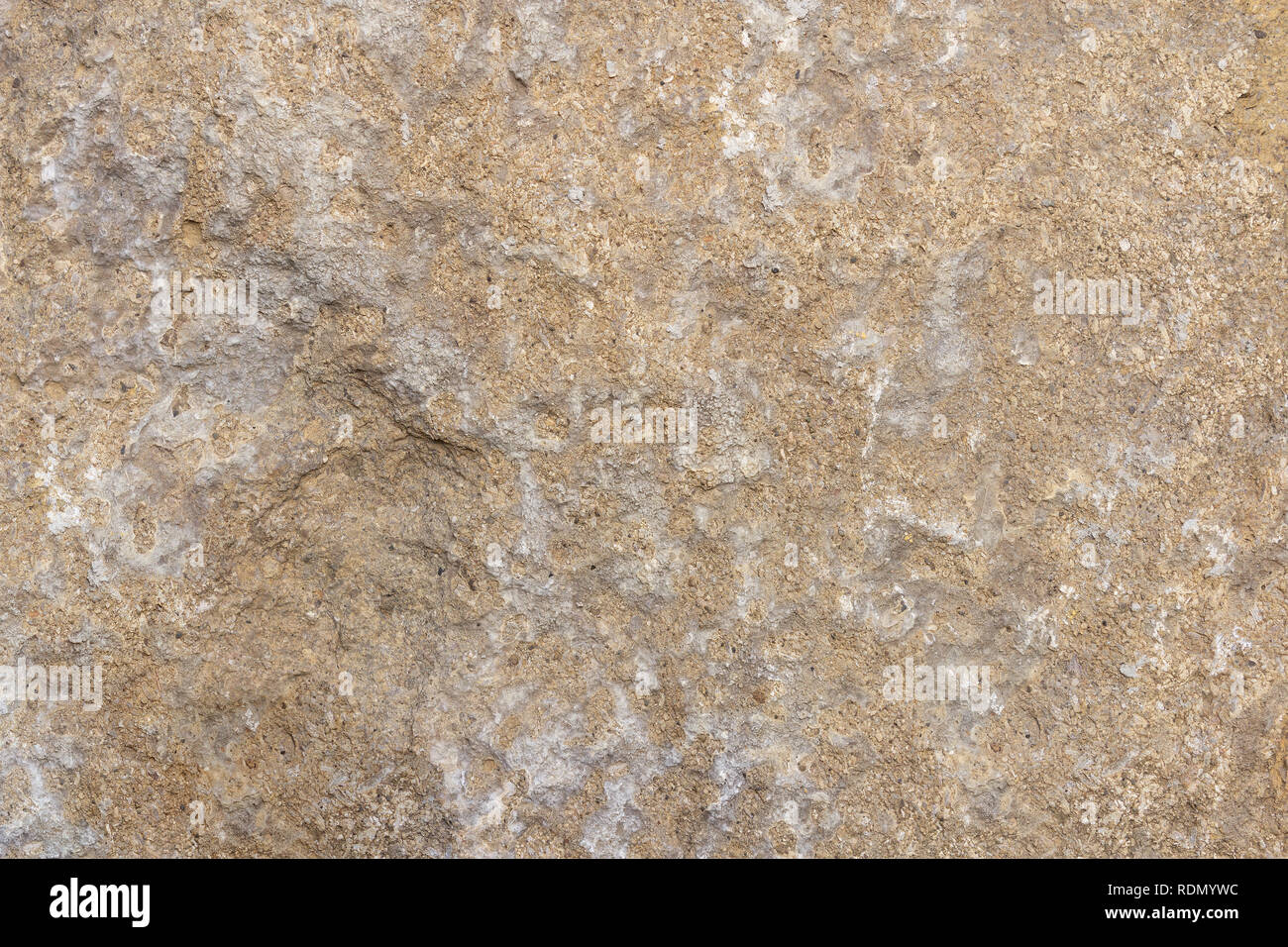 Natural light brownstone with a relief surface. Rock texture Stock