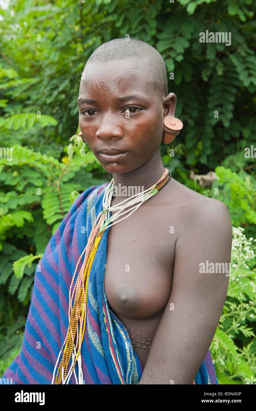 Young Surma woman with scarifications and earlobe plates, Tulgit, Omo River Valley, Ethiopia, Africa Stock Photo