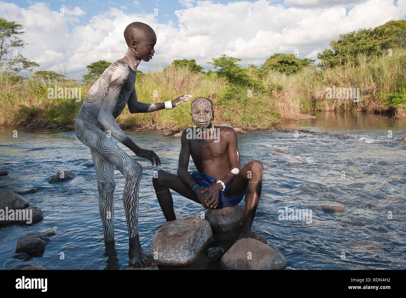 Two Surma men with facial and body paintings in the river, Kibish, Omo River Valley, Ethiopia, Africa Stock Photo
