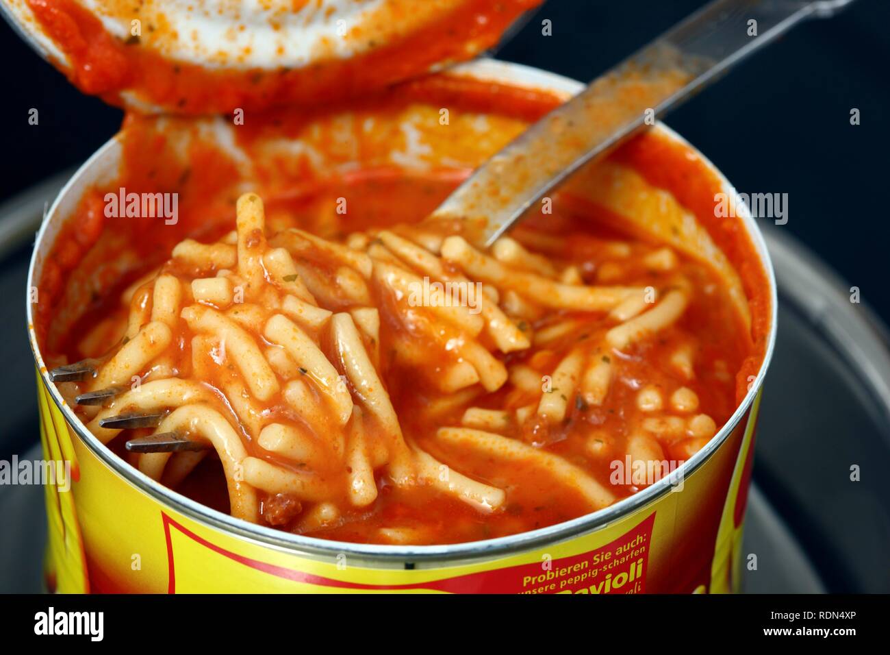 Reheating an instant meal in a tin can in a water bath, Spaghetti Bolognese Stock Photo