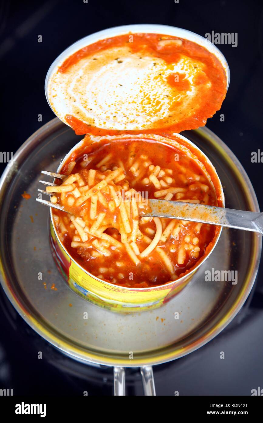 Reheating an instant meal in a tin can in a water bath, Spaghetti Bolognese Stock Photo