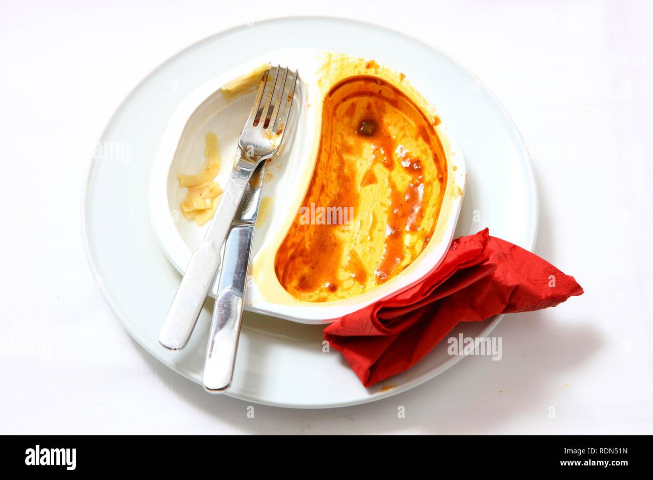 Remains of a pre-prepared meal after being eaten, served on a plate, in the original packaging Stock Photo