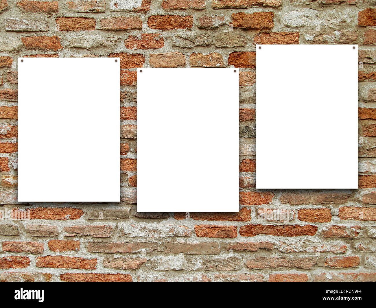 Three blank frames on brown weathered brick wall background Stock Photo