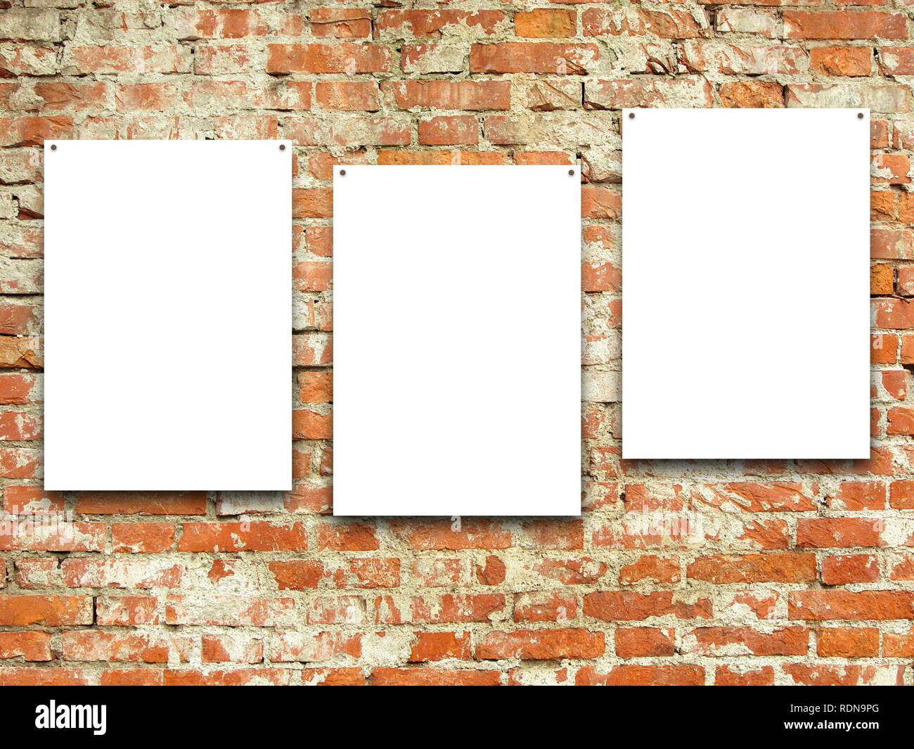Three blank frames on orange weathered brick wall background Stock Photo