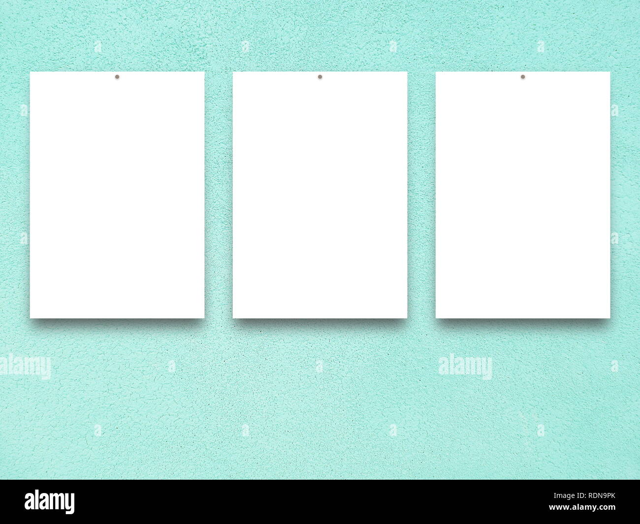 Three blank frames on aqua plaster wall background Stock Photo