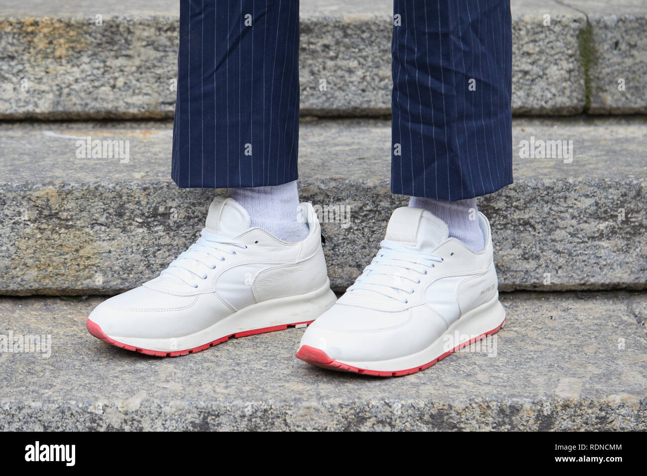 MILAN, ITALY - JANUARY 12, 2019: Man with white sneakers with red sole and  blue pinstripe trousers before Frankie Morello fashion show, Milan Fashion  Stock Photo - Alamy