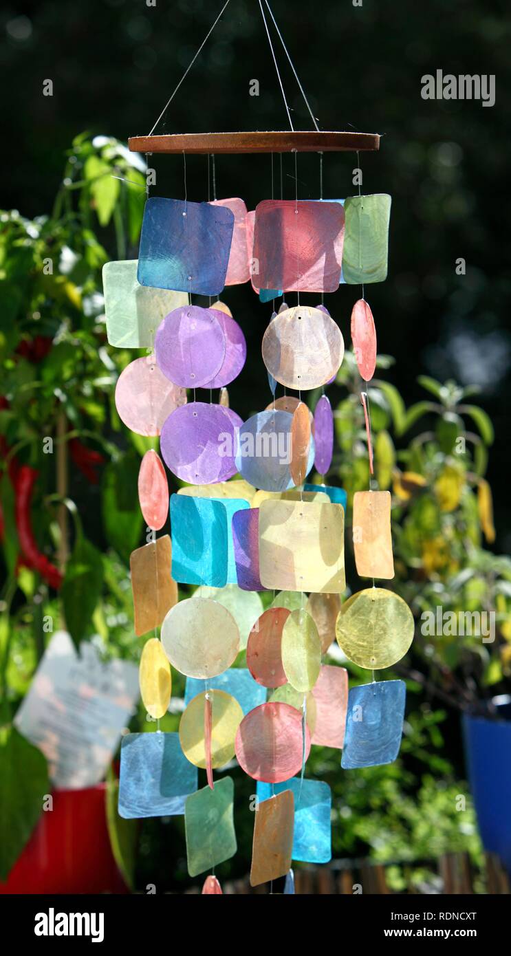 Colourful wind chime made of coloured plastic, hanging outside on a