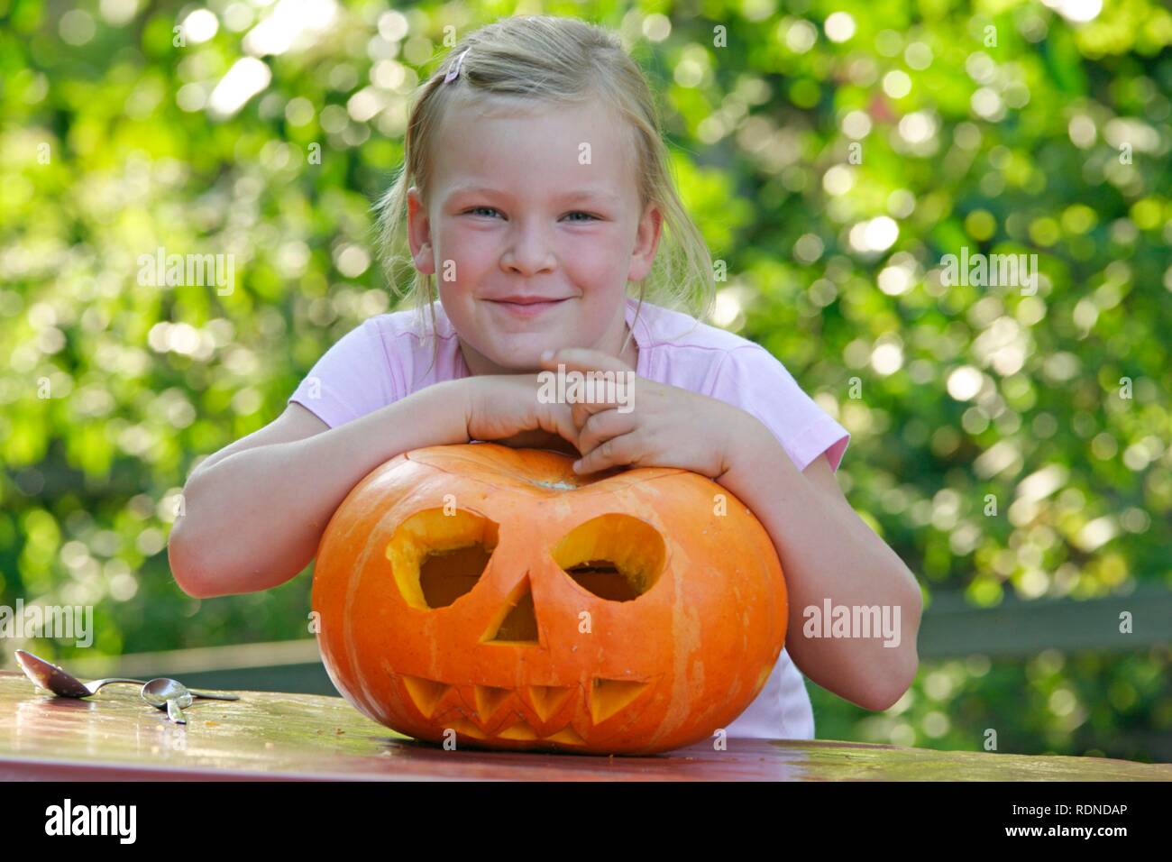 Little girl proudly showing her carved Halloween pumpkin Stock Photo