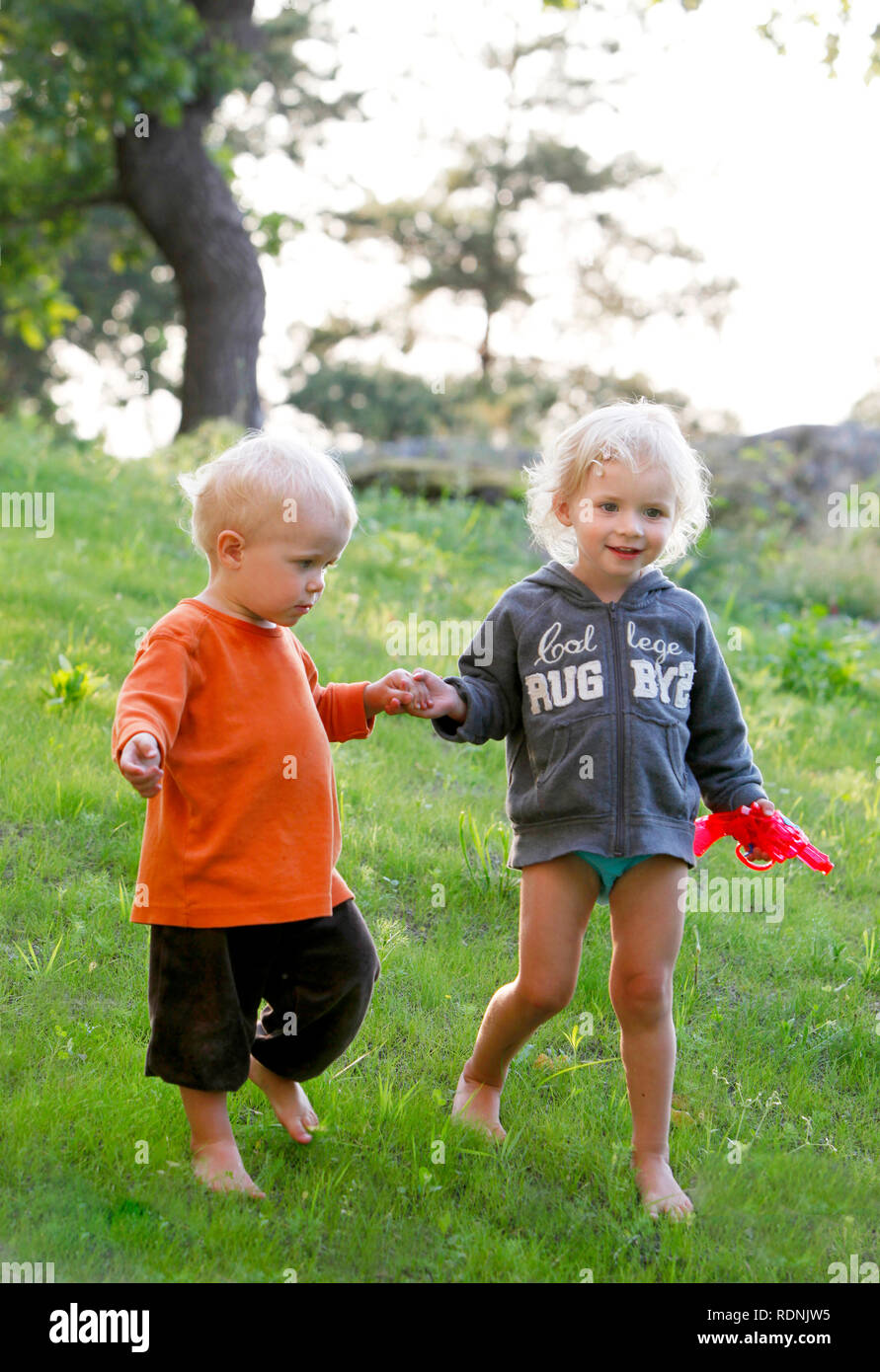 two children walking on the lawn Stock Photo