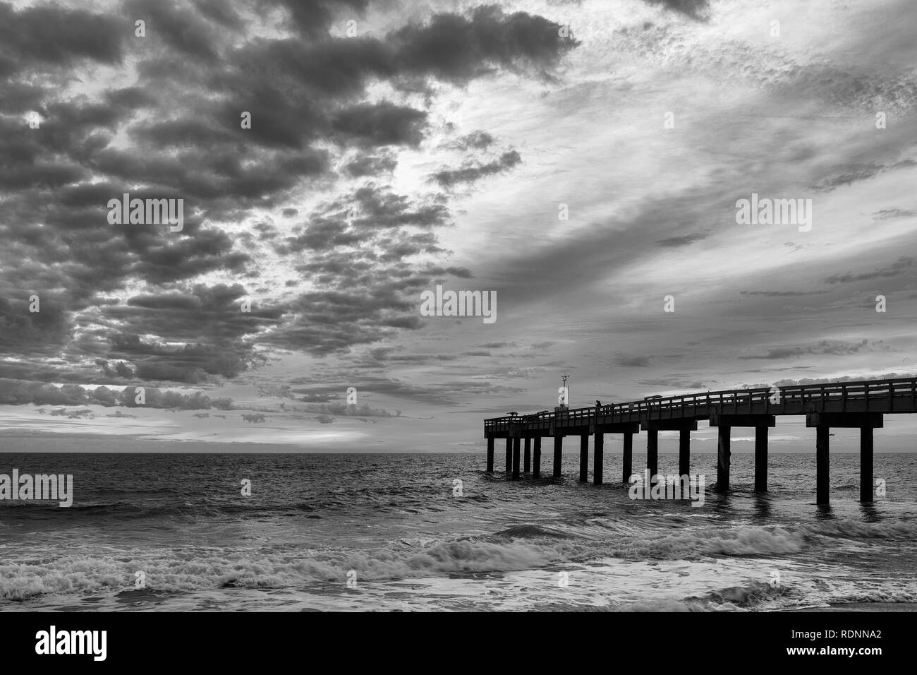 Sunrise in black and white at the St. Augustine Beach Pier, or St. Johns County Ocean Pier, in St. Augustine, Florida Stock Photo