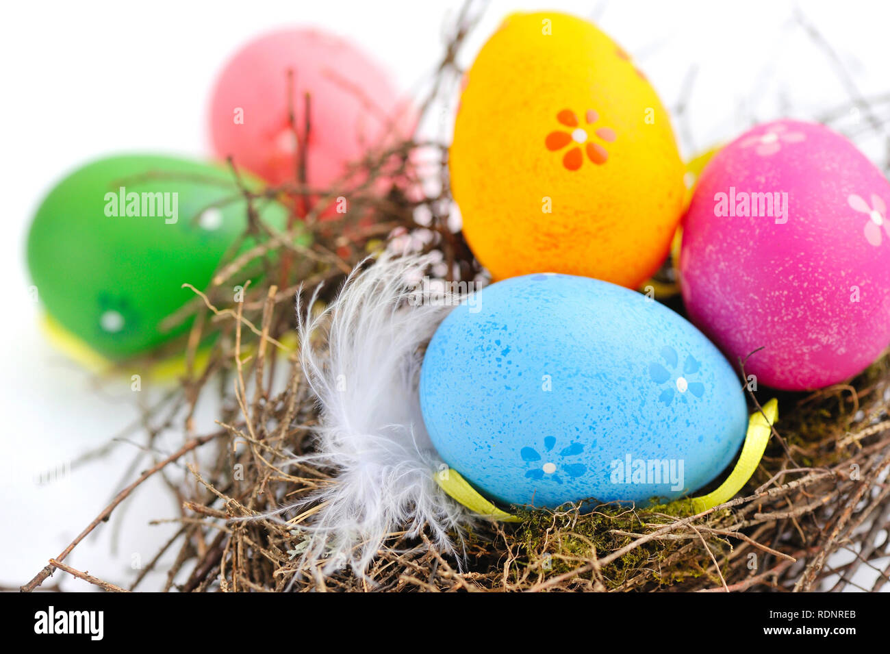 Colorful easter eggs in nest on a white background Stock Photo - Alamy