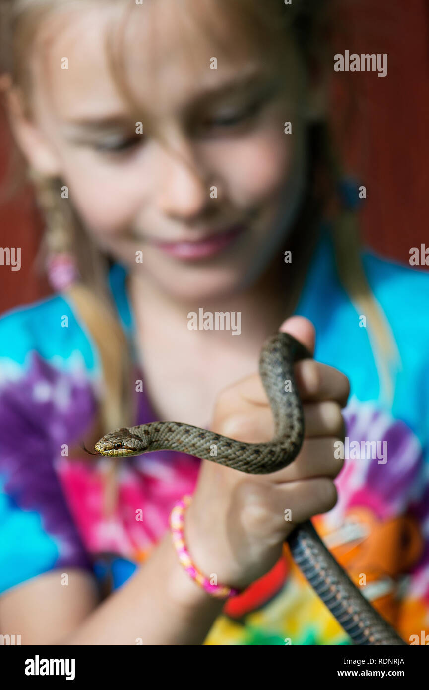 Girl holding snake Stock Photo