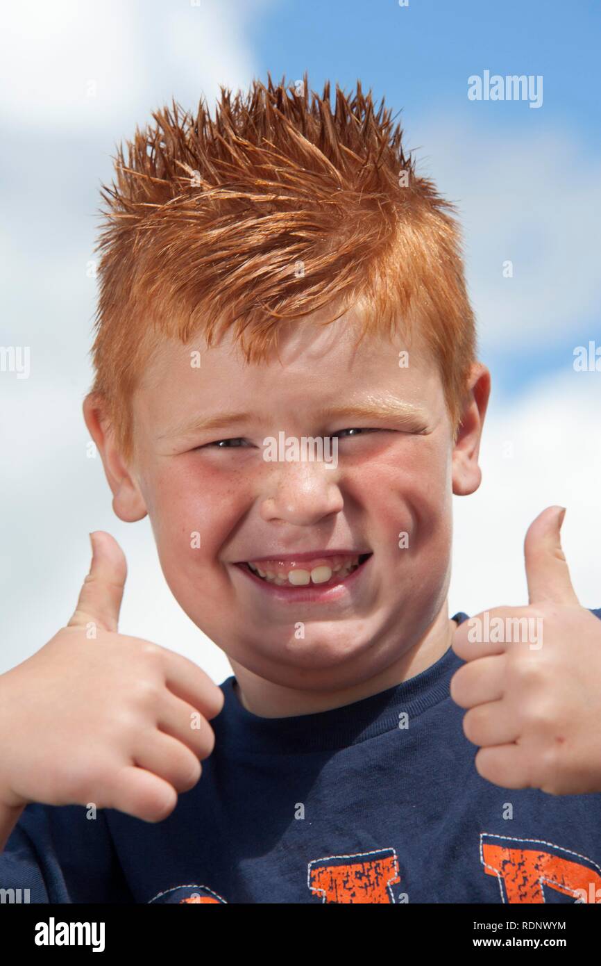 Red-haired Irish boy giving the thumbs up, Ballymun, Dublin, Republic of Ireland, Europe Stock Photo