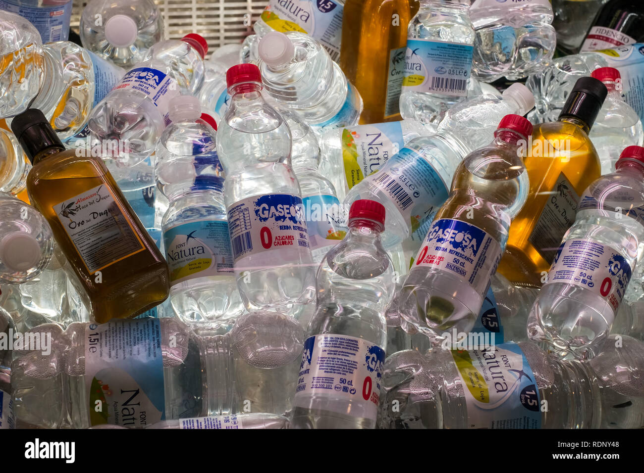 Soft drinks bottles and olive oil in the refrigerated display case