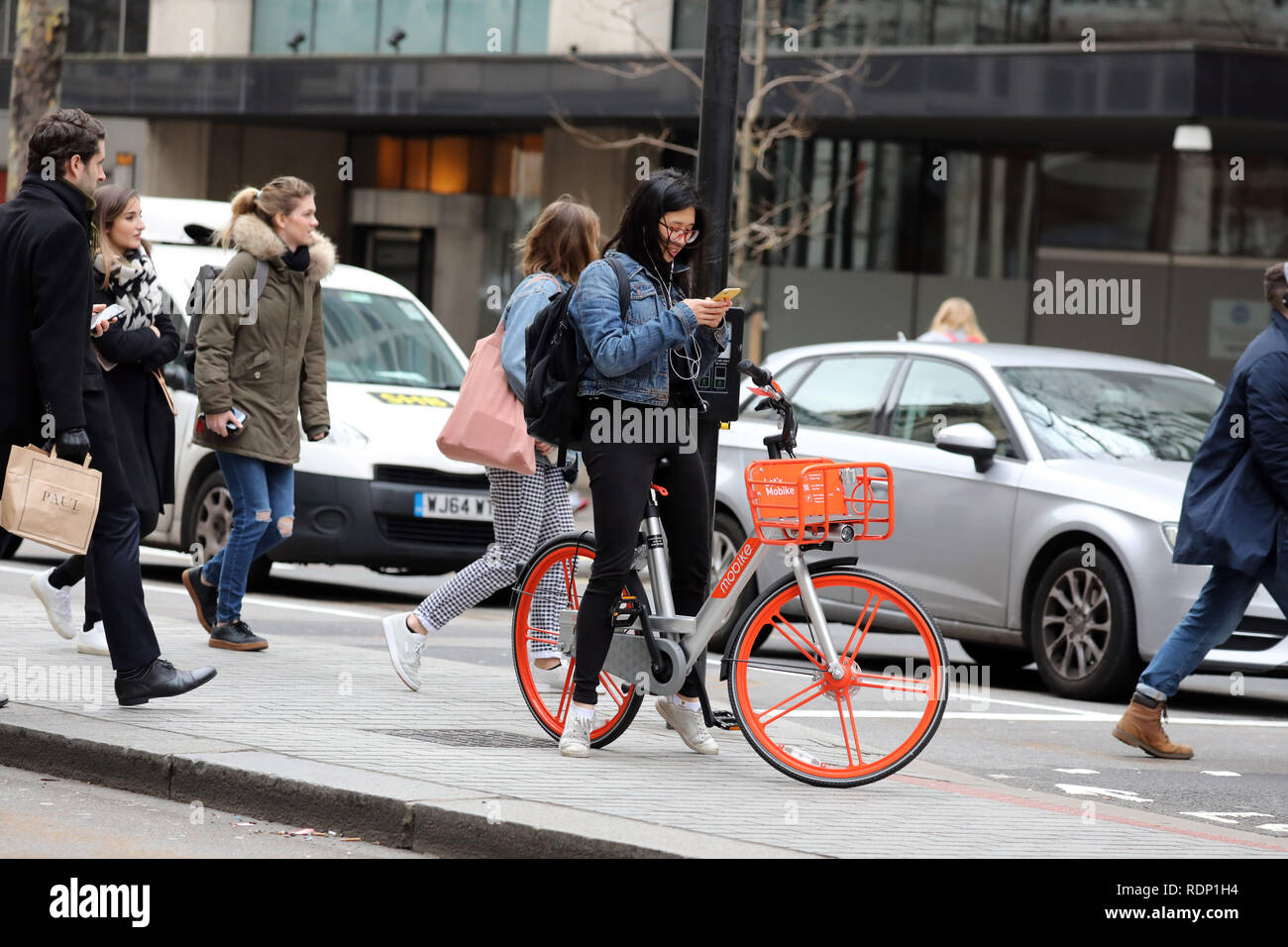 woman on hire bike looking at phone Stock Photo