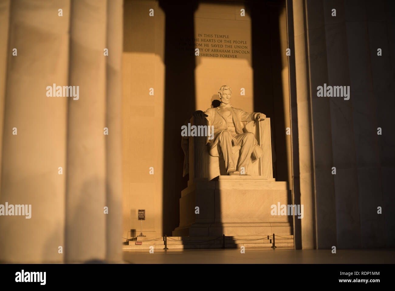 WASHINGTON DC, United States - Early morning at the Lincoln Memorial in Washington DC. Sitting on the western end of the National Mall, it commemorates the 16th president of the United States, Abraham Lincoln. This photo was taken around the spring solstice. With the sun rising directly in the east, the light briefly shines directly onto the massive statue of Lincoln that sits deep inside the building. Stock Photo