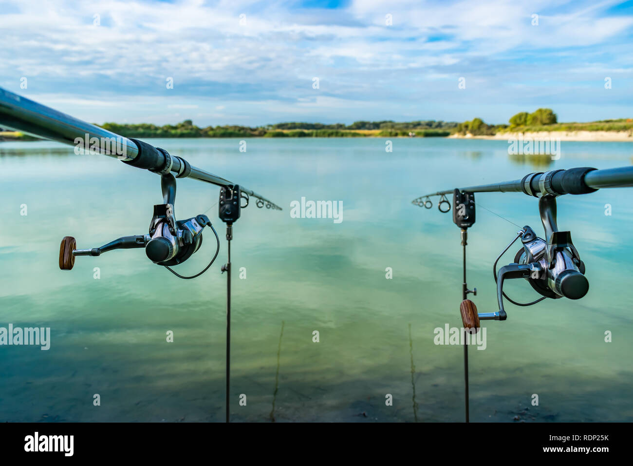 View of two fishing rods on stands with electronic lights on the background  of a beautiful green lake Stock Photo - Alamy