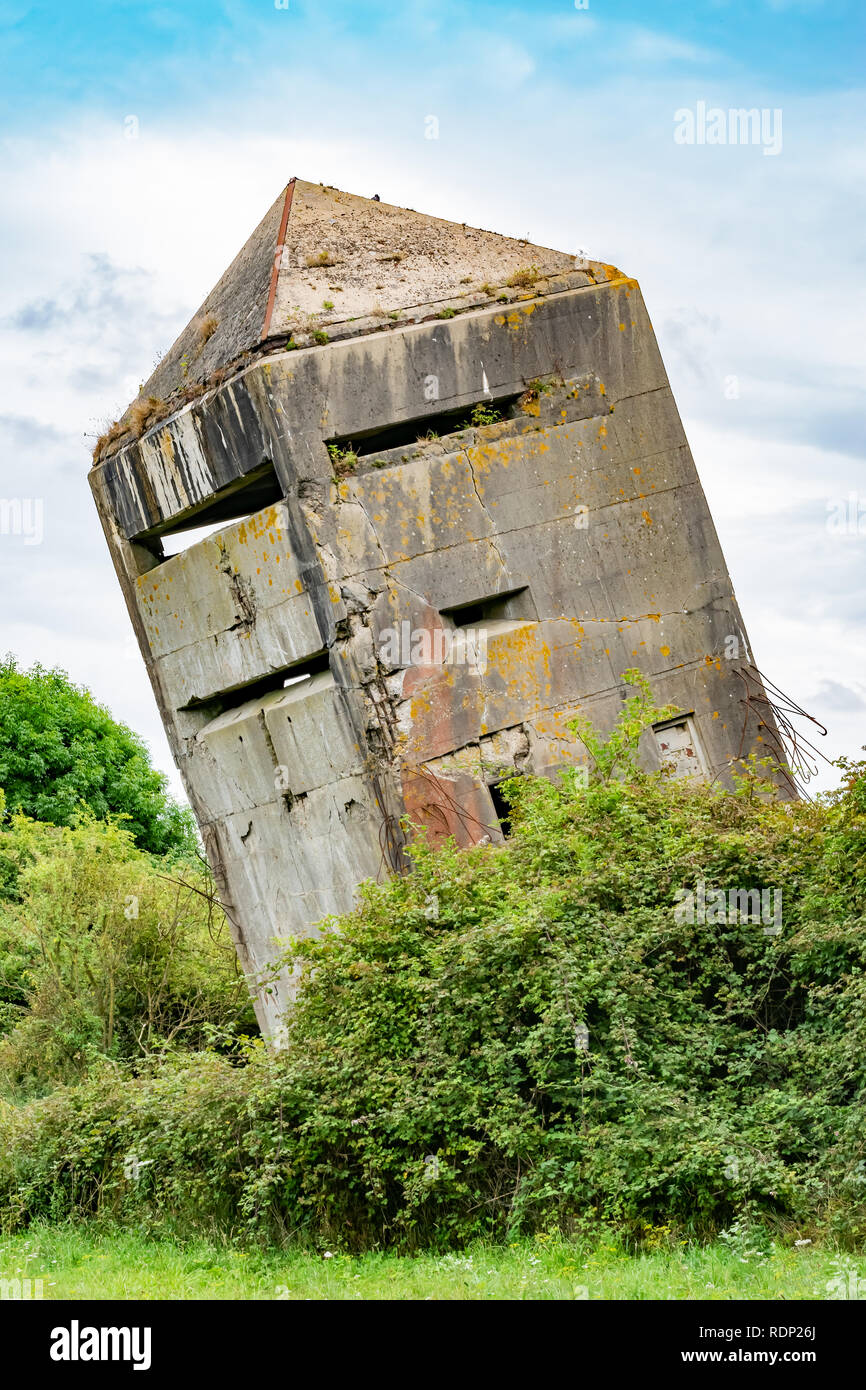 Tilted original old German bunker from World War II La Tour Penchee (the leaning tower) in Oye Plage, Nord-Pas-de-Calais, France. Stock Photo