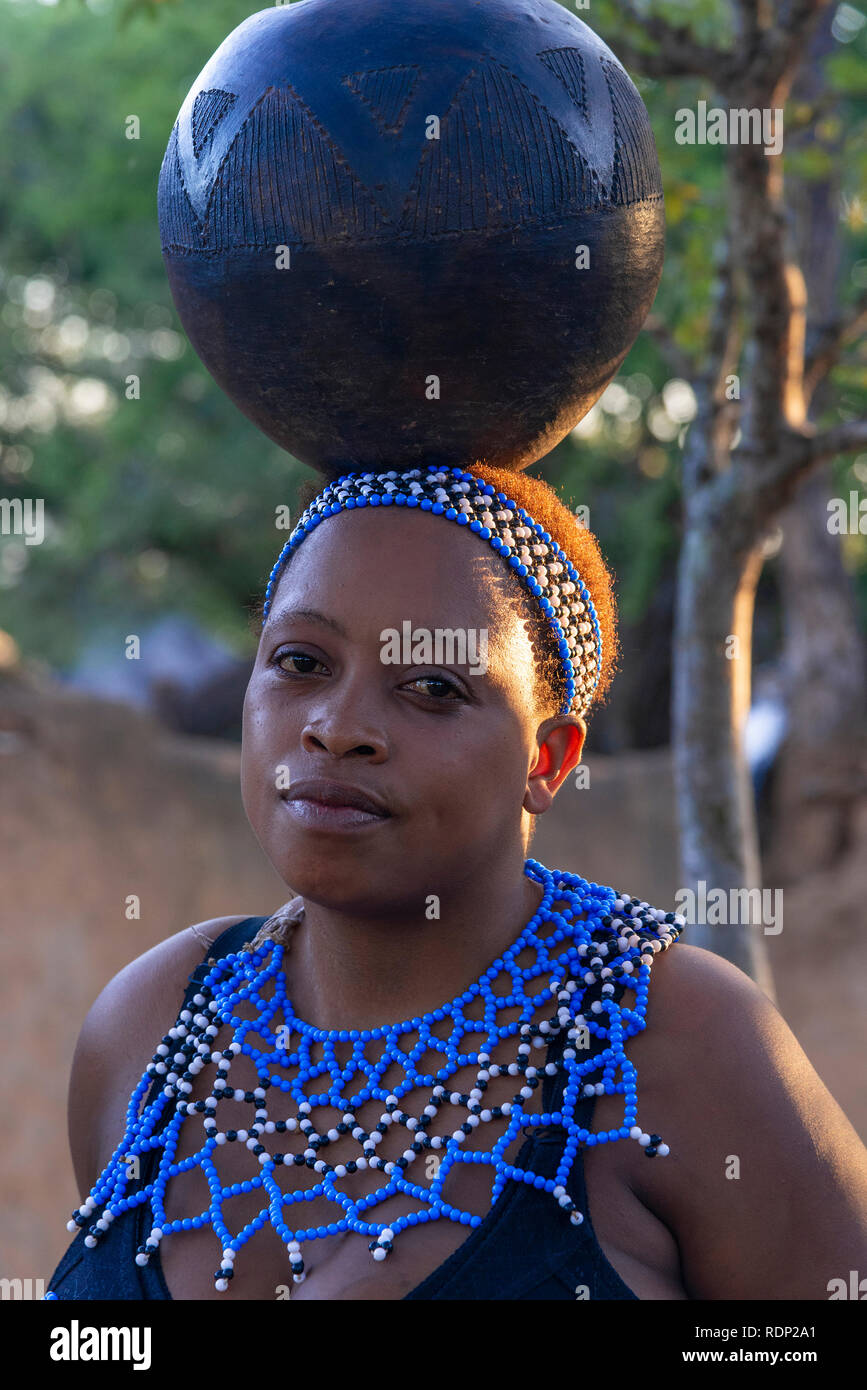 Zulu girl  performer balancing blue pot on her head at the Shakaland Zulu Cultural Village,Eshowe, KwaZulu-Natal, South Africa Stock Photo