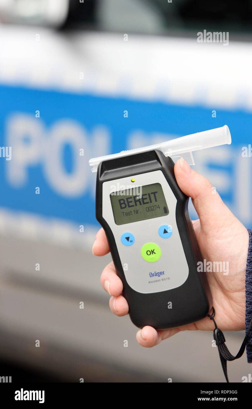 Police officer with breathalyser for checking the fitness to drive Stock Photo