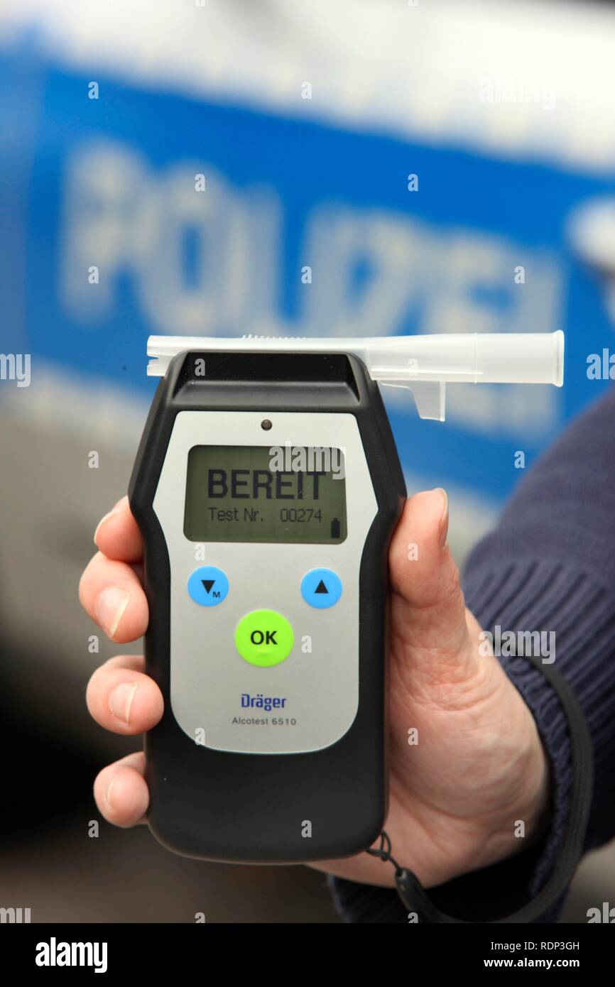 Police officer with breathalyser for checking the fitness to drive Stock Photo