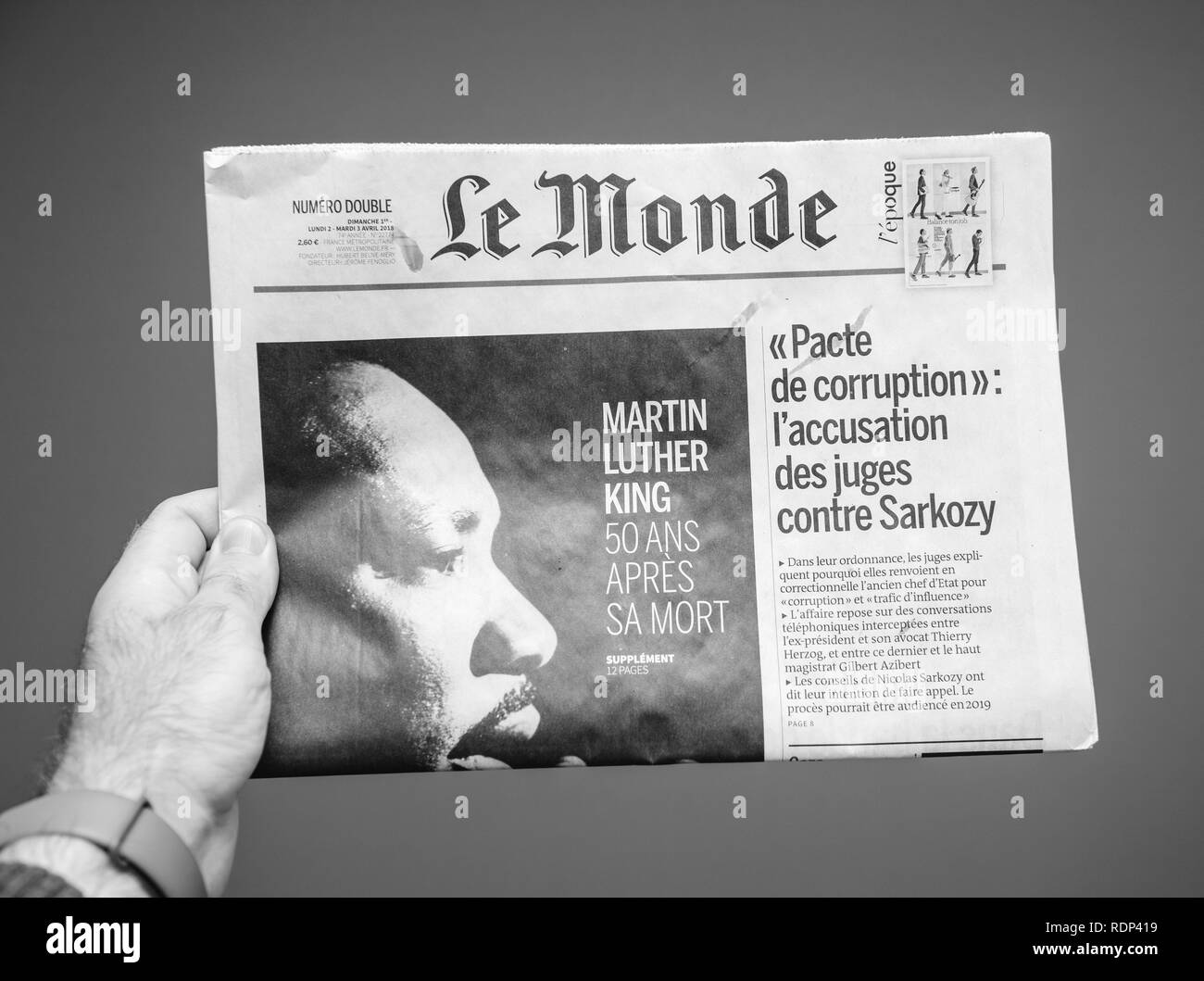 PARIS, FRANCE - APR 3, 2018: Man holding Le Monde newspaper front page against white background with the picture of the Martin Luther King death 50th anniversary - black and white photo  Stock Photo