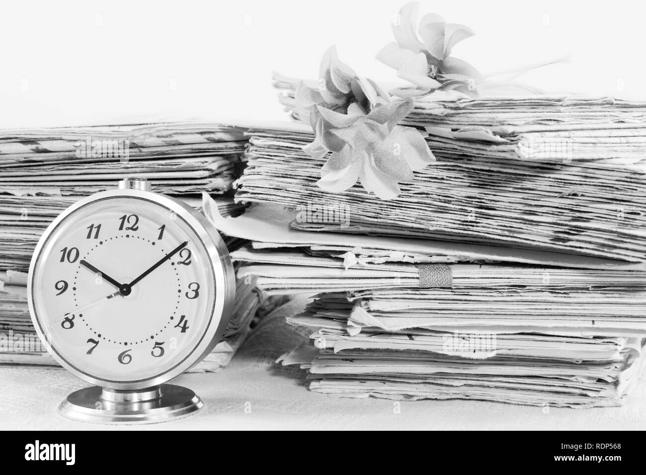 Old mechanical clock and pile of the paper postal mails, black and white Stock Photo