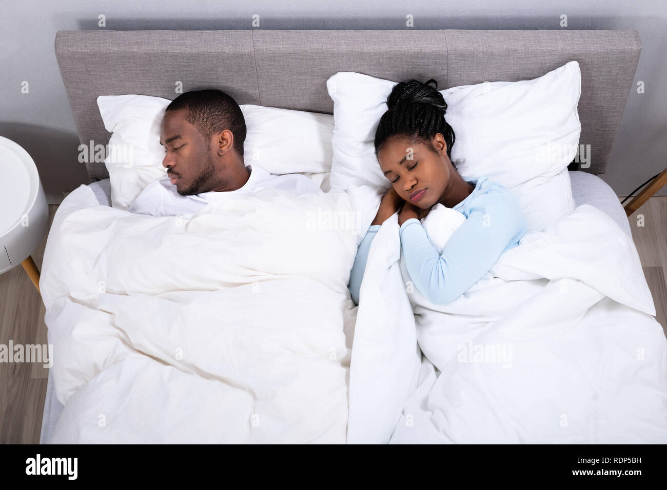 High Angle View Of Young African Couple Sleeping On Bed Stock Photo