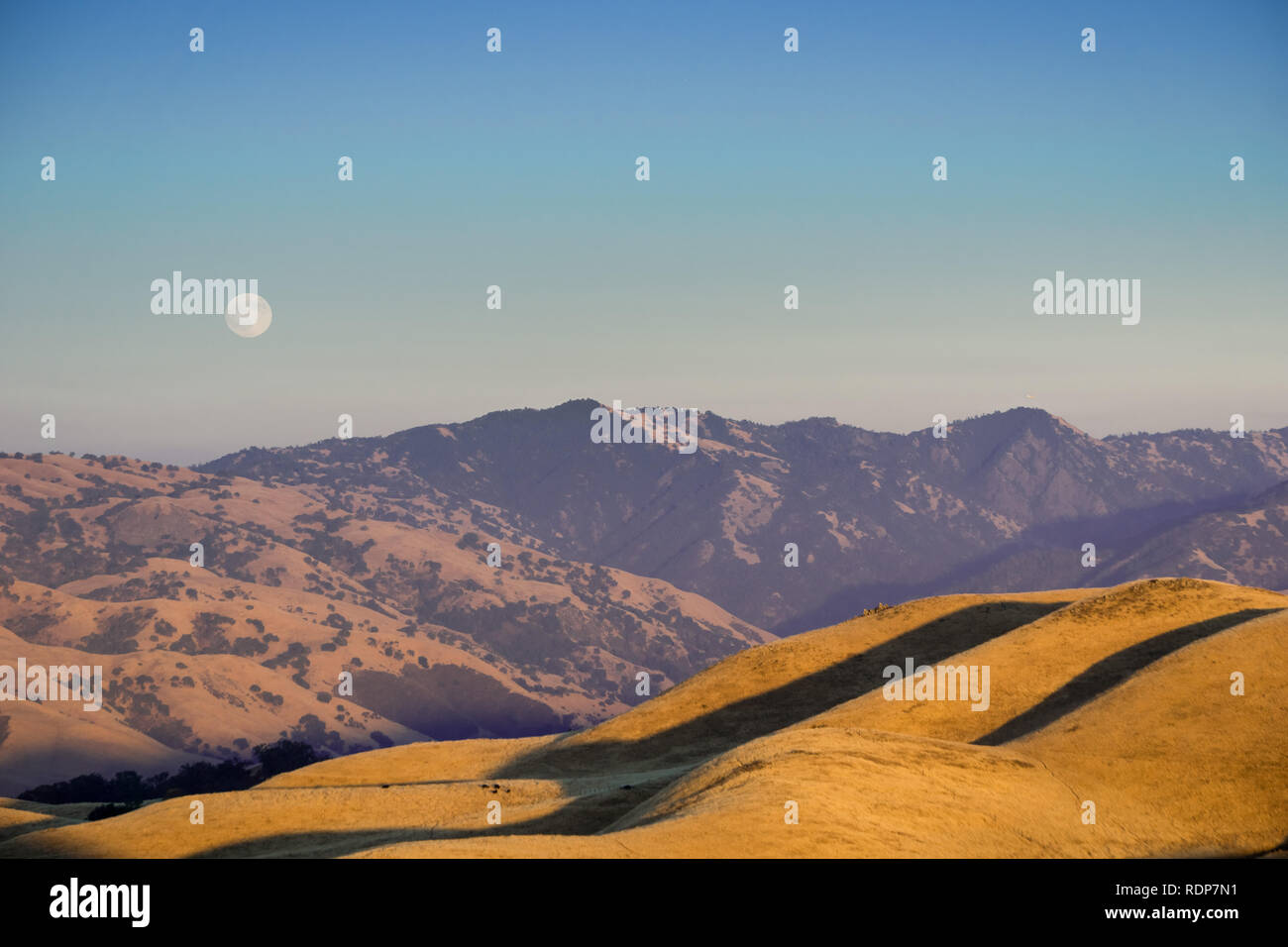 Golden hour and full moon rising over the hills and valleys of Ohlone Regional Wilderness, view from Mission Peak; south San Francisco bay area, Calif Stock Photo