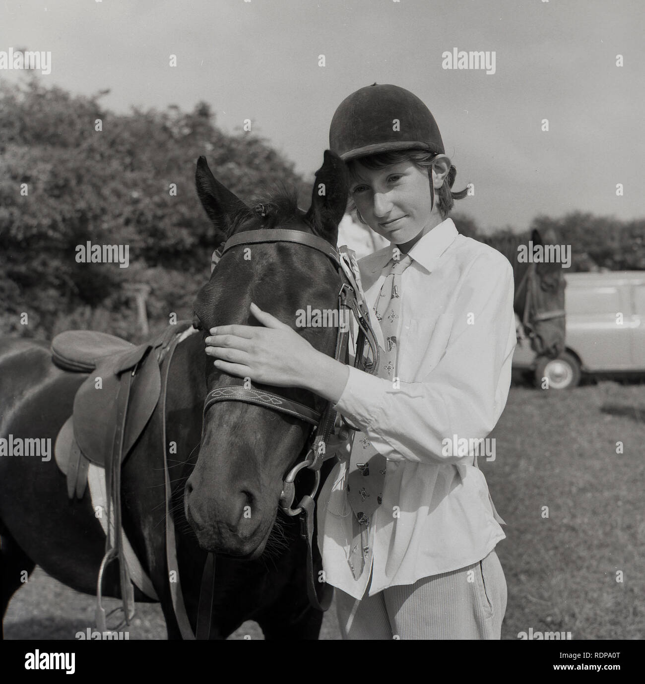1967, historical, outside in a field at an equestrian event, girl rider ...
