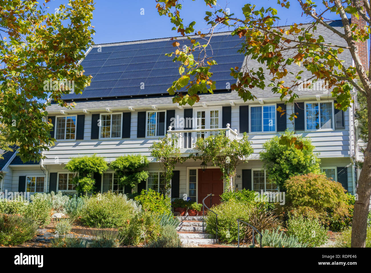 House with solar panels on the roof in a residential neighborhood of Oakland, in San Francisco bay on a sunny day, California Stock Photo