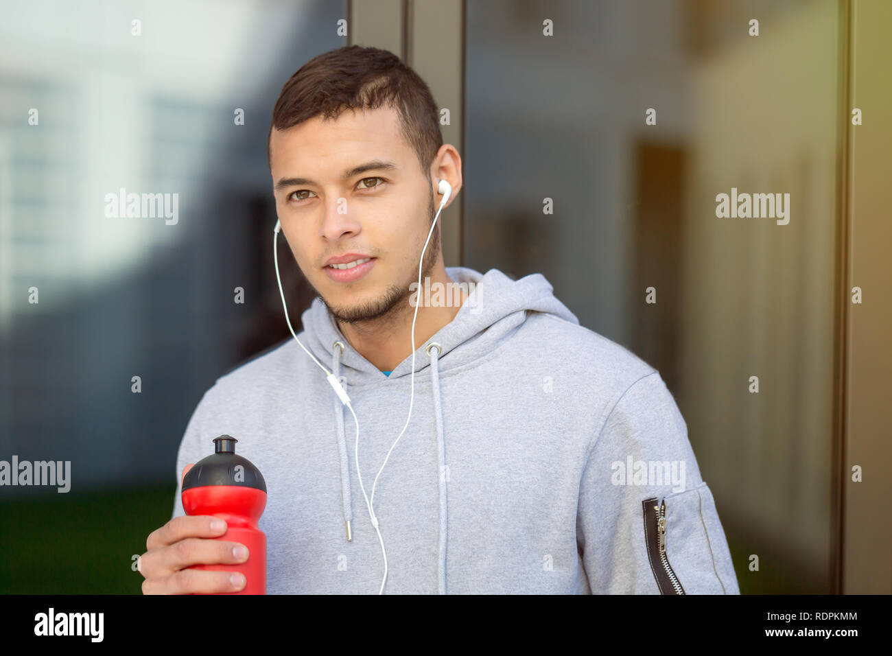 Drinking water young man runner running looking thinking jogging sports training fitness outdoor Stock Photo