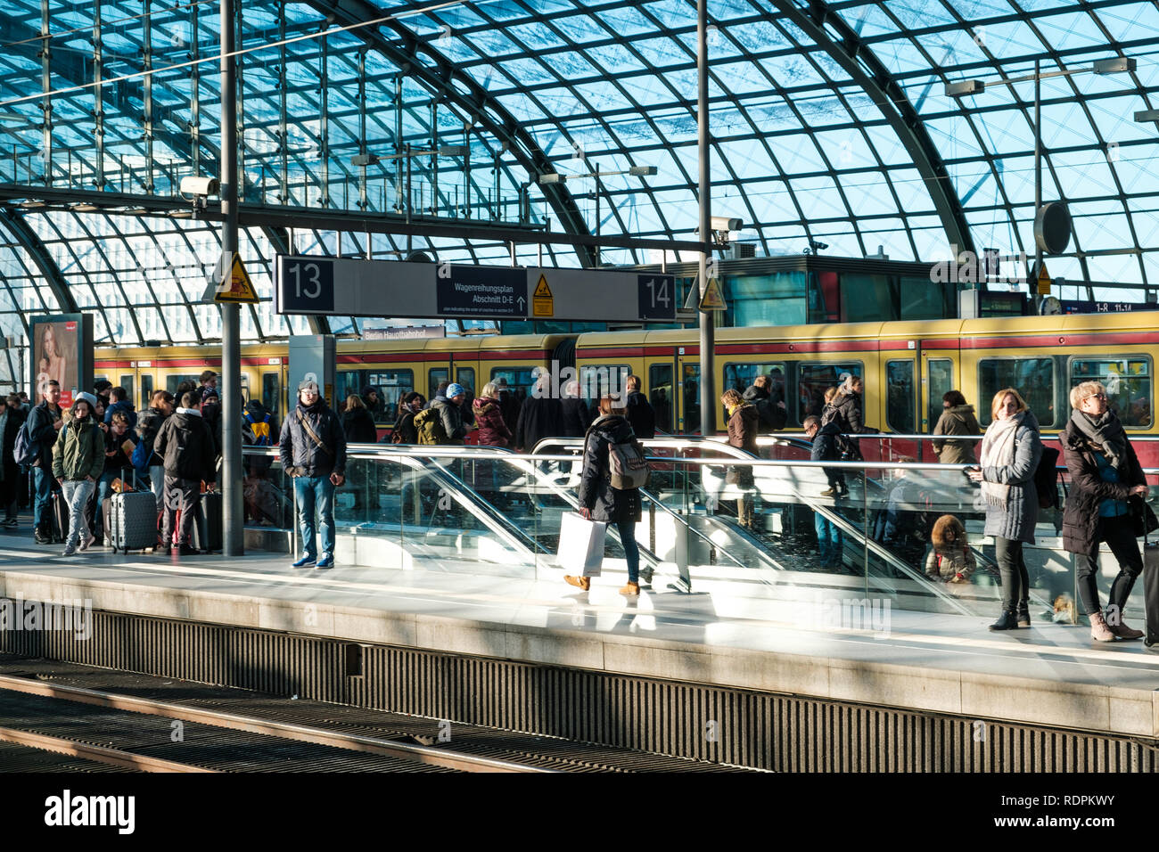 Berlin, Germany - january 2019:   People waiting for train on railroad plattform, Berlin Hauptbanhof ( Main Station)  in Berlin, Germany, Stock Photo